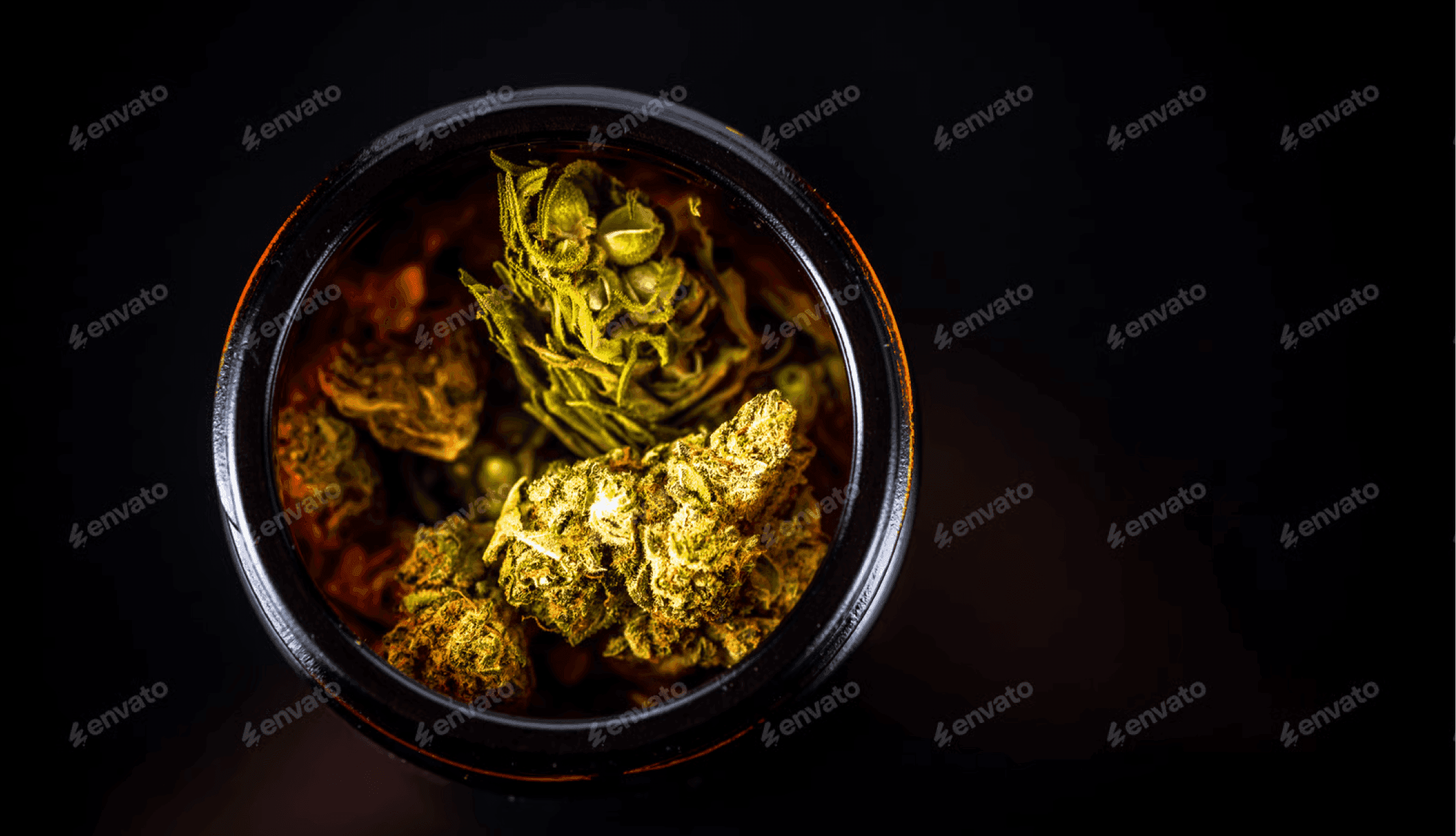 Ein braunes Glas mit Cannabisblüten, von oben gesehen.